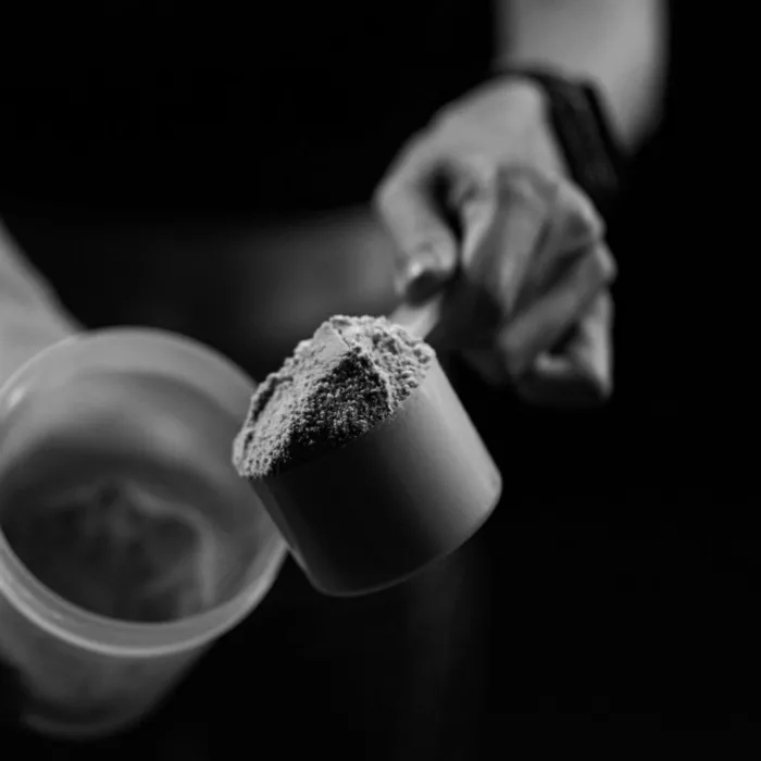 cerca-mujeres-cucharada-medicion-proteina-suero-botella-agitadora-preparando-batido-proteinas
